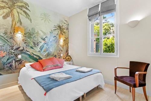 a bedroom with a bed and a window and a chair at Chalet au bord de l'eau in Fréjus