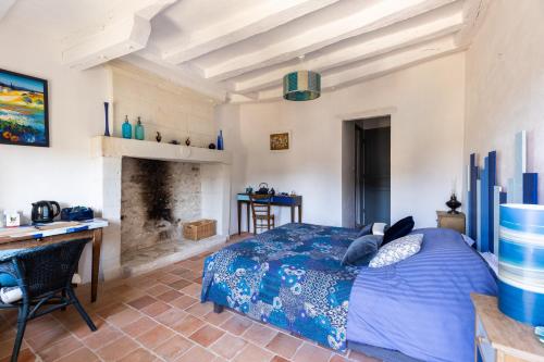 a bedroom with a bed and a desk and a fireplace at Au Bo Voyage in Tavant