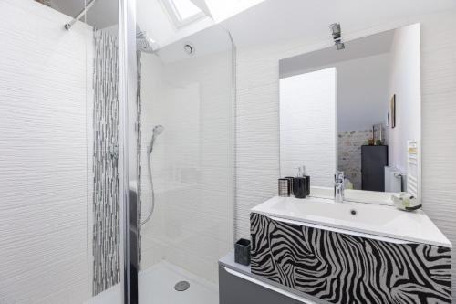 a bathroom with a zebra print sink and a shower at Au Bo Voyage in Tavant