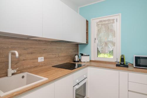 a kitchen with white cabinets and a sink at Villa Clelia in Palau