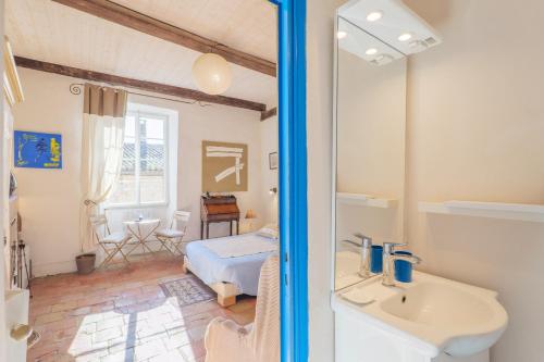 a bedroom with a bed and a sink and a mirror at Laho - Chambre d'hôte in Lagorce