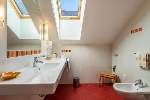 a bathroom with two sinks and a skylight at Haus Rosengarten Apt C in Terlano