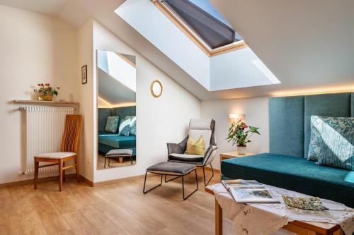 a living room with a green couch and a skylight at Haus Rosengarten Apt C in Terlano