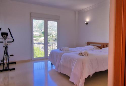a bedroom with two beds and a large window at Luxurius Villa with private pool in Mijas