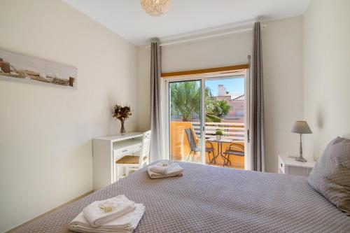 a bedroom with a bed with a view of a balcony at Royal Cabanas Golf 87 in Cabanas de Tavira