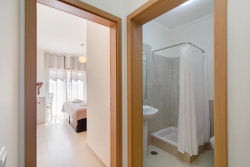 a bathroom with a shower and a toilet and a bed at Royal Cabanas Golf 87 in Cabanas de Tavira
