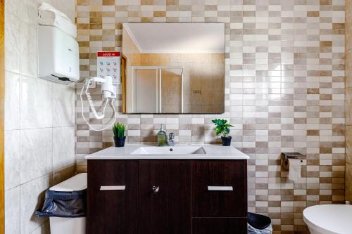 a bathroom with a sink and a mirror and a toilet at Sublime Sun and Van, By Meco Stays in Alfarim