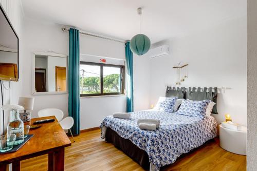 a bedroom with a bed and a desk at Sublime Sun and Van, By Meco Stays in Alfarim