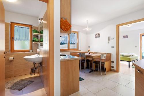 a bathroom with a sink and a kitchen with a table at Innerjerberhof Neiderseit in Lauregno