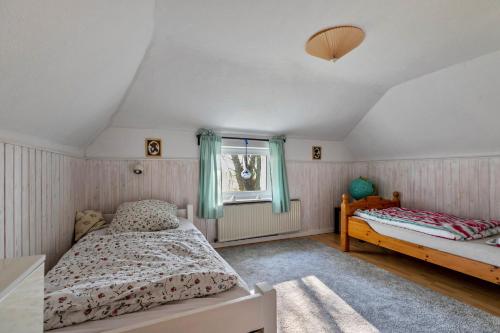 a bedroom with two beds and a window at Ferienhaus Busch in Elpersbüttel