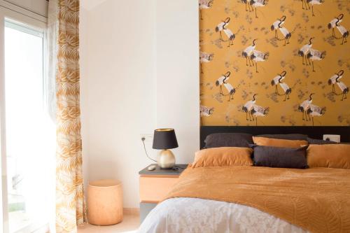 a bedroom with a bed with a yellow wall at Constance in L'Ampolla