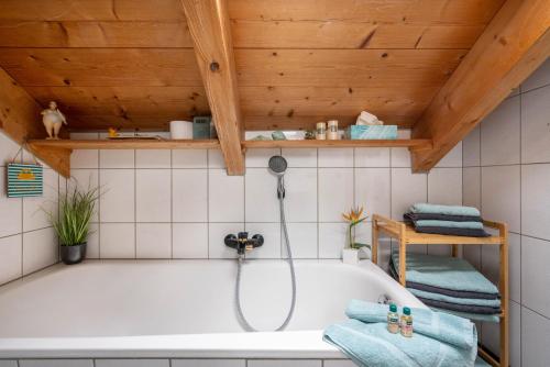 a bath tub in a bathroom with a wooden ceiling at Ferienwohnung Breitenberger in Herrsching am Ammersee