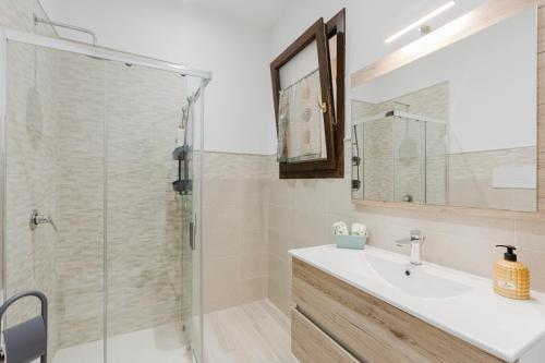 a bathroom with a sink and a glass shower at Casa Vacanza Iris Castelvetrano in Castelvetrano Selinunte