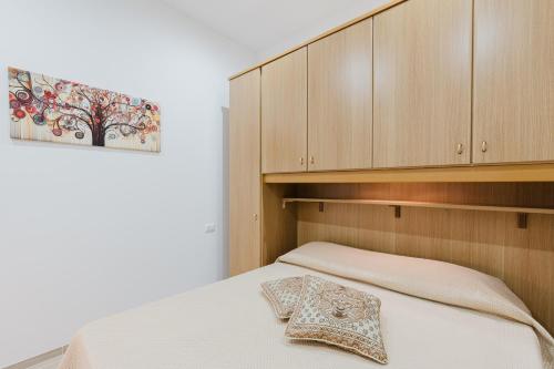 a bedroom with a bed and wooden cabinets at Casa Vacanza Iris Castelvetrano in Castelvetrano Selinunte