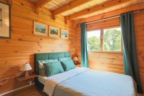 a bedroom with a bed in a log cabin at Chalet Pondok Indah in Plouégat-Moysan