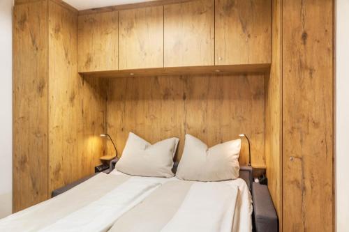 a bedroom with a bed with a wooden wall at Haus Excelsior Top 31 in Seefeld in Tirol