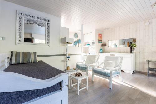 a bedroom with a bed and a table and chairs at Villa Cap Ferret - Réf 230 in Lège-Cap-Ferret