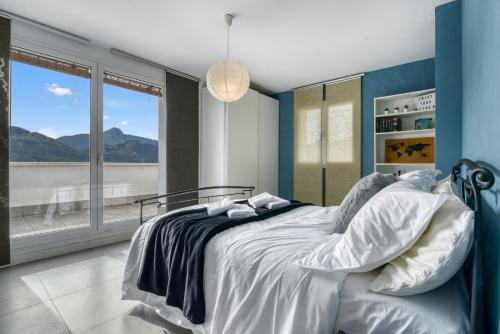 a bedroom with a large bed with blue walls at Villa Sol in Orba