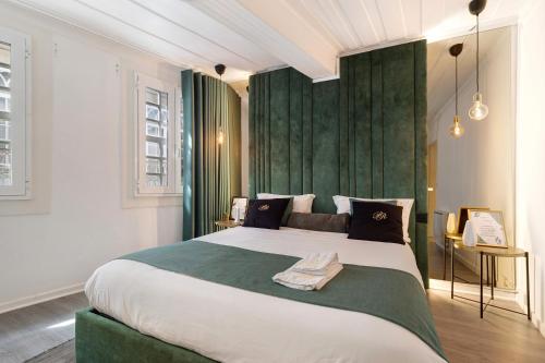 a bedroom with a large bed with a green headboard at Prestigegoldresidence 1 - Old Town in Guimarães