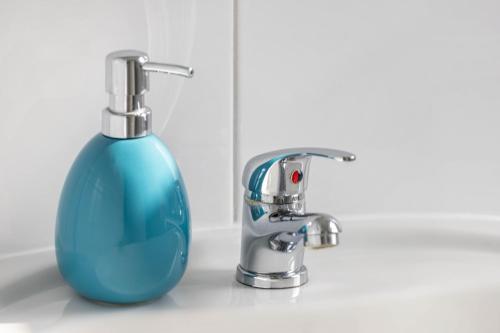 a blue soap bottle next to a bathroom sink at Schweden Apartment in Kerken