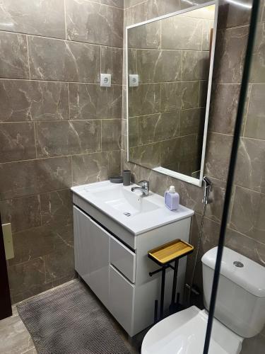 a bathroom with a sink and a toilet and a mirror at Mouramar Vilamoura in Vilamoura
