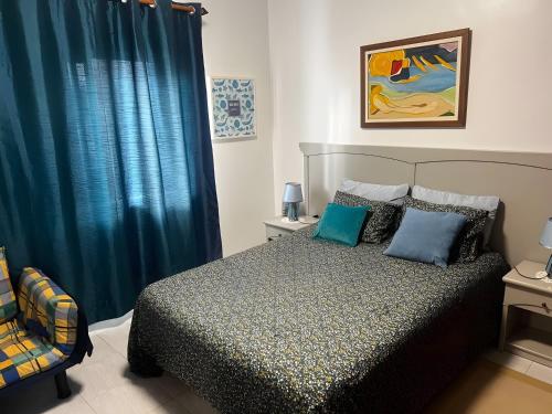 a bedroom with a bed and a blue curtain at Mouramar Vilamoura in Vilamoura