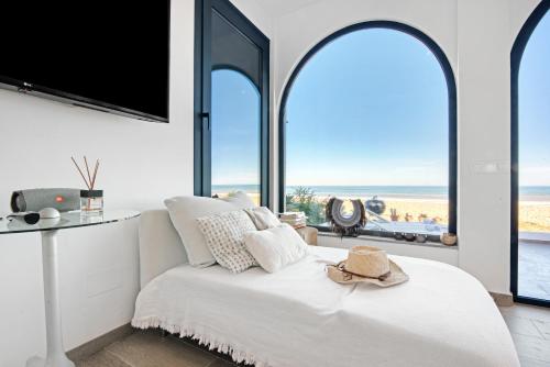 a bedroom with a bed with a view of the ocean at Denia Beach Lodge in Denia