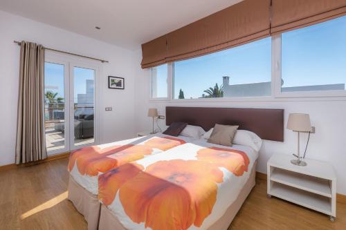 a bedroom with a large bed and a large window at Villa Costa Eugenia in Cala d´Or