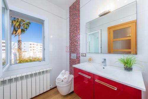 a bathroom with a red sink and a window at Villa Costa Eugenia in Cala d´Or