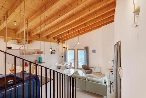 a living room with wooden ceilings and a table and chairs at Ca dela Nua front lake in Limone sul Garda