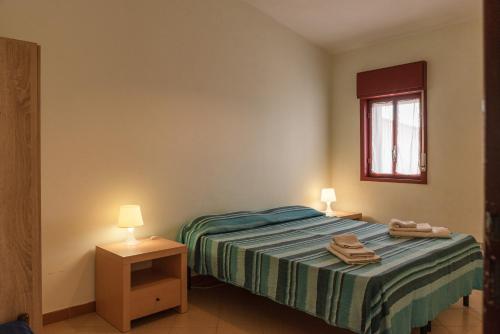 a bedroom with a bed and two lamps and a window at Appartamento A - Le Terrazze in Ribera