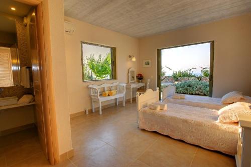 a bedroom with a bed and a table and a window at Villa Linatela Ideales Resort in Kefallonia