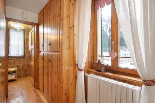 a room with wooden walls and a window and a radiator at Apartment Corti Garden in Campodolcino