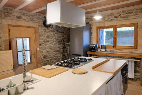 a kitchen with a stove and a white counter top at Masia Sa Calma - La Tribu in Susqueda