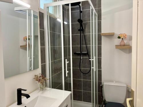 a bathroom with a shower with a toilet and a sink at Ty Foch in Lorient