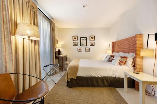 a hotel room with a bed and a desk and a chair at Liberal Wing Villa in Portimão