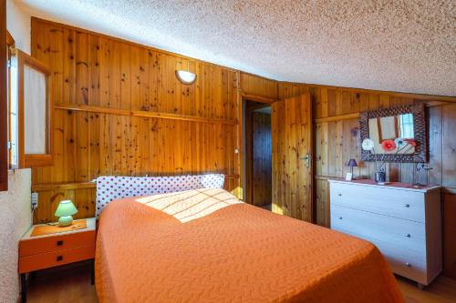 a bedroom with a bed and a wooden wall at Ciumara East in Avola