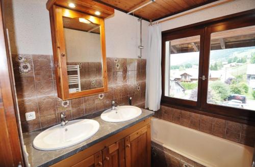 a bathroom with two sinks and a tub and a window at Le Mont de Grange in La Chapelle-dʼAbondance