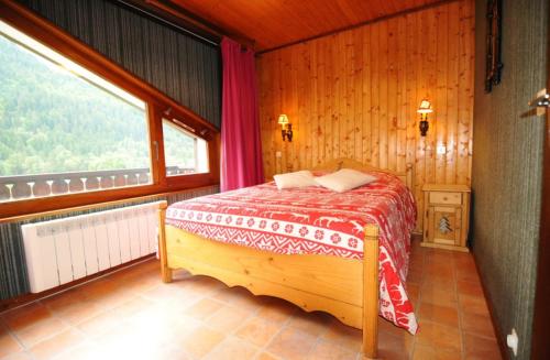 a bedroom with a bed in a room with a window at Le Mont de Grange in La Chapelle-dʼAbondance