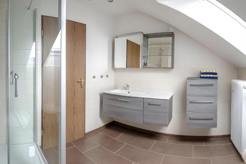 a bathroom with a sink and a shower at Ferienhaus Nanny Und Helene in Uphusum