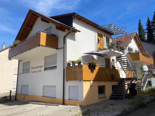 a large white building with a staircase on it at Ferienwohnungen Hubertus in Metzingen