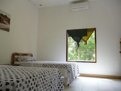 Giường trong phòng chung tại Dewi Garden Guesthouse