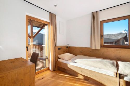 a bedroom with a bed and a window and a desk at Lechnerhof - Clara´s Mountain Lodge in Rodengo