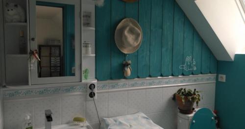 a bathroom with blue walls and a mirror and a sink at Gîte Shabby Blue in Saint-Cernin
