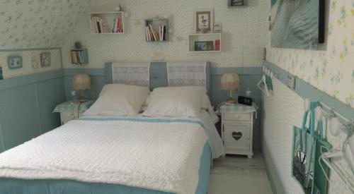 a small bedroom with a bed and a night stand at Gîte Shabby Blue in Saint-Cernin