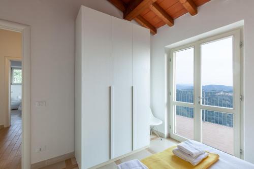 a room with white cabinets and a large window at Villa Martina in Pietrasanta