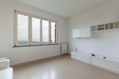 a white kitchen with a large window and white appliances at Villa Martina in Pietrasanta