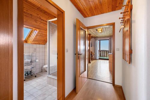 a hallway with wood ceilings and a hallway with a bathroom at Weingut Geiger in Meersburg