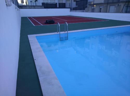 a swimming pool with a blue light in a building at Barra Sol - Lighthouse On The Beach in Gafanha da Nazaré