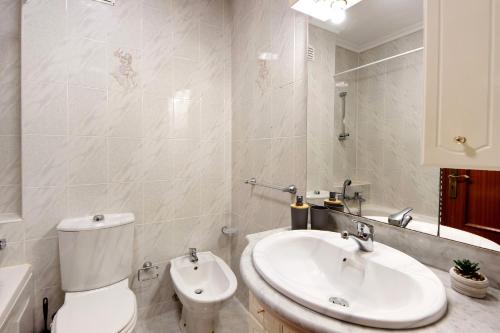 a bathroom with a white toilet and a sink at Barra Sol - Lighthouse On The Beach in Gafanha da Nazaré